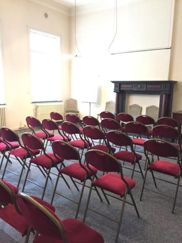 a group of chairs in a room with a fireplace at Villa Theresa à 25 min de PAIRI DAIZA in Soignies