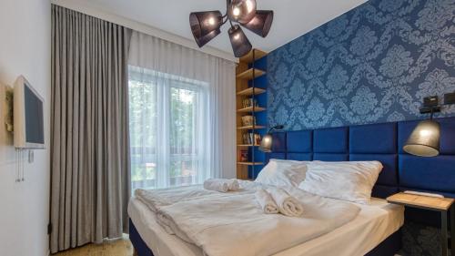 sypialnia z łóżkiem z niebieską ścianą w obiekcie Apartament 41 Holiday Mountain Residence - 5D Apartamenty w Świeradowie Zdroju