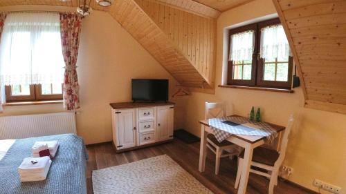 a bedroom with a bed and a desk with a television at Uroczysko starych sztolni in Szklarska Poręba