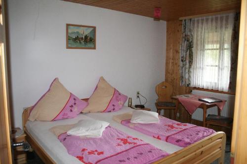a bedroom with a bed with pink and white sheets at Wäldebauernhof in Gutach