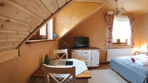 a attic room with a bed and a bed and a tv at Uroczysko starych sztolni in Szklarska Poręba