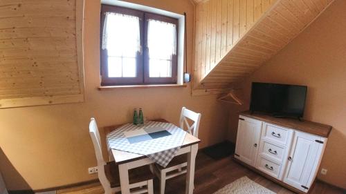 a dining room with a table and a tv and a window at Uroczysko starych sztolni in Szklarska Poręba