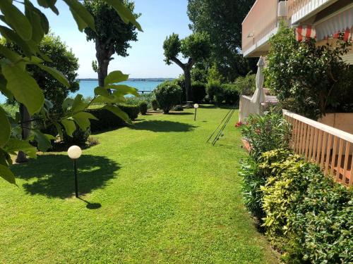 a yard with green grass and a house at Lake Front Luxury Apartment in Sirmione