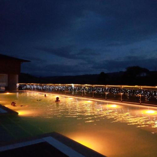 a swimming pool with people in the water at night at SPA HOTEL Gora in Bukovel