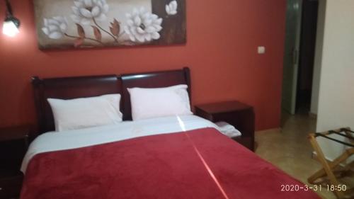 a bedroom with a bed with a red wall at Palatino in Loutra Edipsou
