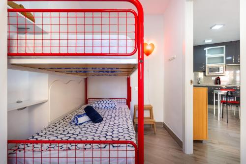 a red bunk bed in a room with a kitchen at Apartamento primera linea playa Algarrobo Costa in Algarrobo-Costa