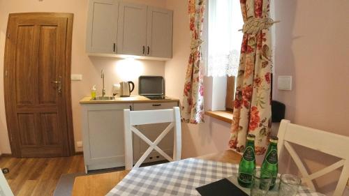 a small kitchen with a table with bottles on it at Uroczysko starych sztolni in Szklarska Poręba