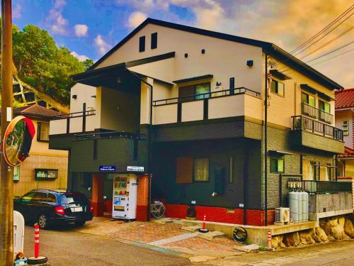 a house with a car parked in front of it at Midtown Sakura Apartment House 202 予約者だけの空間 A space just for you in Nachikatsuura