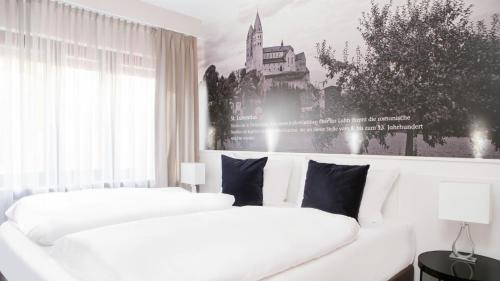 拉恩河畔林堡的住宿－Hotel Huss Limburg，白色客房内的两张白色床,墙上挂着一幅画