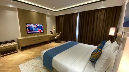 a hotel room with a bed and a flat screen tv at Ocean Delight Boutique Hotel 海悦精品酒店 in Sihanoukville