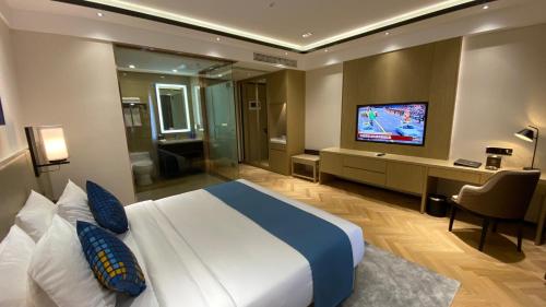 a bedroom with a large bed and a television in it at Ocean Delight Boutique Hotel 海悦精品酒店 in Sihanoukville