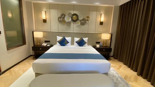 a hotel room with a large bed and two chairs at Ocean Delight Boutique Hotel 海悦精品酒店 in Sihanoukville