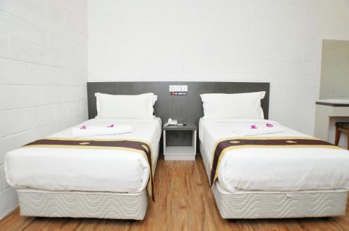 two beds sitting next to each other in a room at Promenade Service Apartment in Kota Kinabalu
