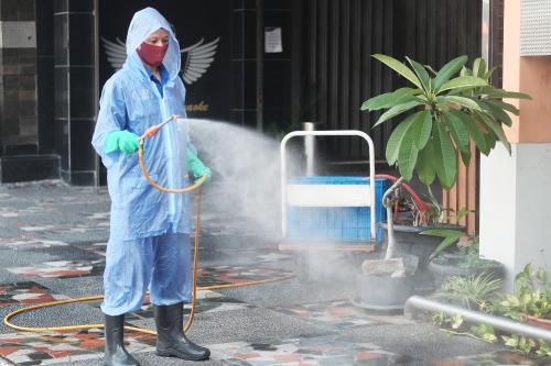 a person in a raincoat andmask standing with a hose at Holiday Villa, Lanta in Ko Lanta