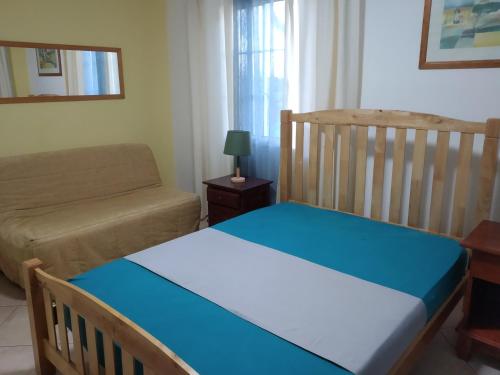 1 dormitorio con cuna y sofá en CôtéMontagne2, en Cilaos