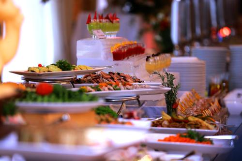 a buffet with plates of food on a table at Araliya Red - Budget friendly Hotel- Where you find stunning 360 panoramic view of Nuwara Eliya in Nuwara Eliya