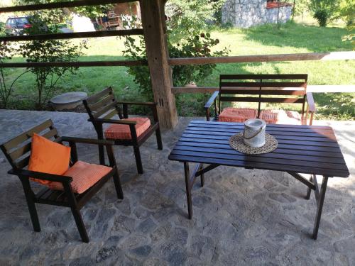 a picnic table and chairs on a patio at Vetrovi šumijo I in Kapele