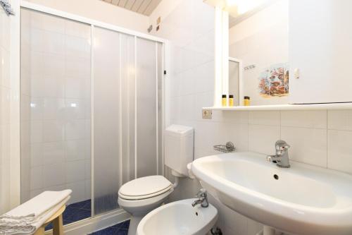a white bathroom with a toilet and a sink at San Francisco rooms in Marina di Andora