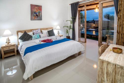 a bedroom with a large bed and a balcony at Private Room Kayu Bunga in Canggu