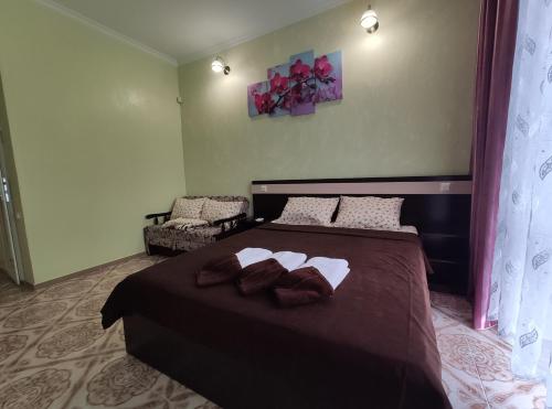 a bedroom with a large bed and a chair at Lyubavushka in Zatoka