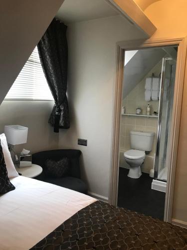 a bedroom with a bed and a bathroom with a toilet at Ashbourne House in York