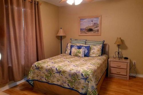 a bedroom with a bed and a lamp and a window at Grand Caribbean in Pensacola