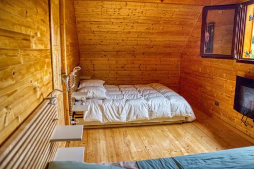 a bedroom with two beds in a wooden cabin at Le chalet de Magali in Briançonnet