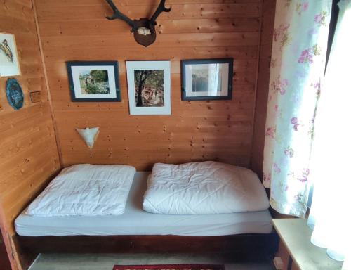 een bed in een hut met foto's aan de muur bij Ferienblockhaus Harzidyll in Wieda