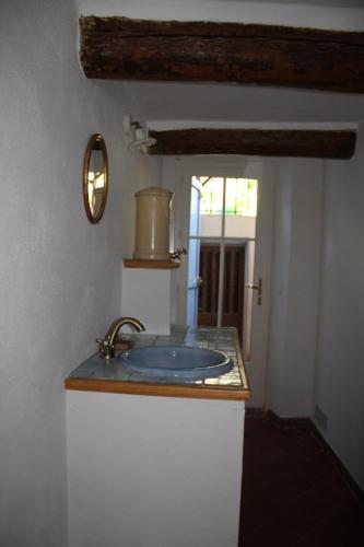 un comptoir de salle de bain avec un lavabo et un miroir dans l'établissement Maison de charme près de la mer, à Bormes-les-Mimosas