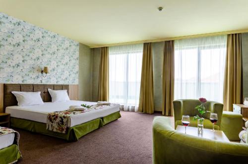 Habitación de hotel con cama y sofá en Alliance Hotel, en Plovdiv