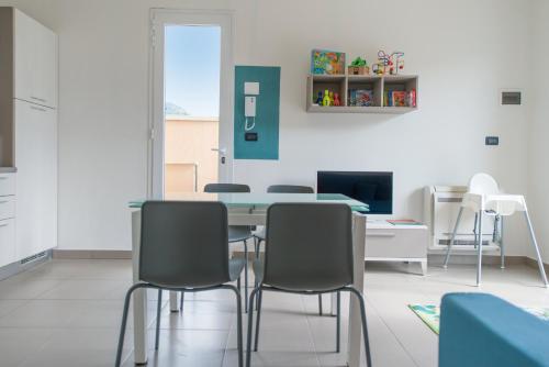 jadalnia ze stołem i krzesłami w obiekcie Babyaccommodation Family Comfort ll w mieście Pietra Ligure