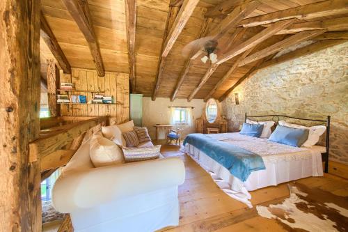 a bedroom in a log cabin with a bed and a couch at HERITAGE Villa DEA RUSTICA in Malinska