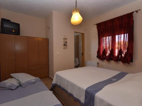 sypialnia z dwoma łóżkami i telewizorem na ścianie w obiekcie Lia Sea View Home - Nea Potidea Halkidiki w mieście Nea Potidaea