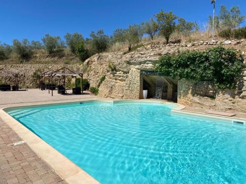 una gran piscina azul frente a una montaña en Agriturismo Baglio Pollicarini, en Pergusa