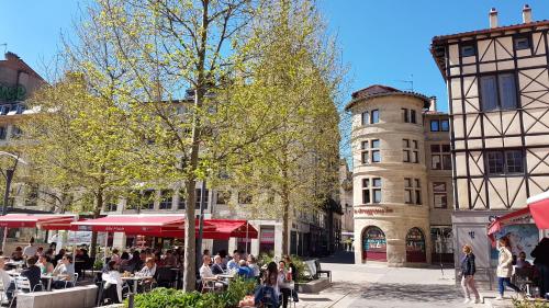 a group of people sitting at tables on a city street at ibis budget Saint-Étienne Centre Gare Châteaucreux in Saint-Étienne