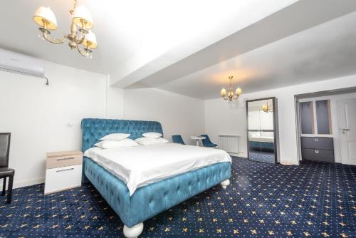 a bedroom with a bed with a blue headboard at Casa Budulan in Drobeta-Turnu Severin