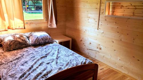 a bedroom with a bed in a log cabin at Eco domki in Ruciane-Nida