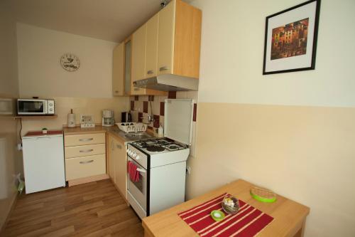 a small kitchen with a white stove and a table at 10 minutes walk to the lakes in Plitvička Jezera