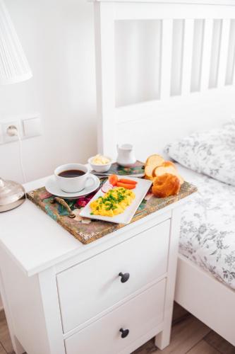 a breakfast table with a plate of food on a bed at Apartament Lubelski Rynek in Lublin