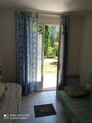 - un salon avec un canapé et une porte coulissante en verre dans l'établissement mas des pins, à Saint-Cyprien