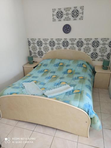 - un lit avec une couette bleue dans une chambre dans l'établissement mas des pins, à Saint-Cyprien