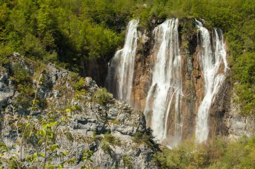 a waterfall on the side of a mountain at 10 minutes walk to the lakes in Plitvička Jezera