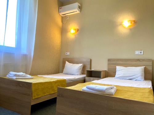 two beds in a hotel room with towels on them at Guest House SOTNI in Kyiv