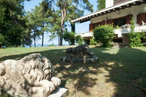a stone lion statue in the yard of a house at Villa Moskoff Amina in Platamonas