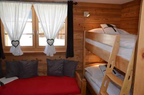 two bunk beds in a log cabin with a window at Apartments Les Marmottes in Zermatt