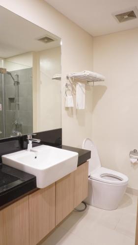 biała łazienka z umywalką i toaletą w obiekcie Citadines Amigo Iloilo w mieście Iloilo