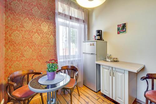 una piccola cucina con tavolo e frigorifero di Toma street apartments a Liepāja