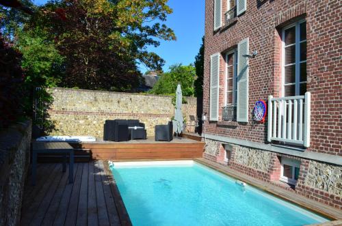 une piscine devant un bâtiment en briques dans l'établissement Stella Etretat, à Étretat