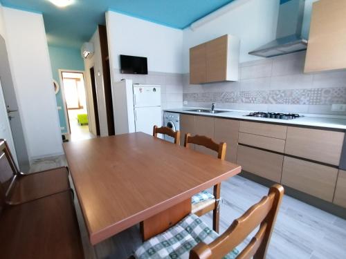 a kitchen with a wooden table and some chairs at Il MARE alla FINESTRA in Cavallino-Treporti