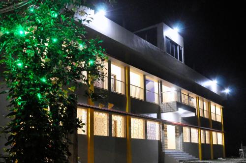 a building at night with green lights on it at Solitary Nook in Gosāba
